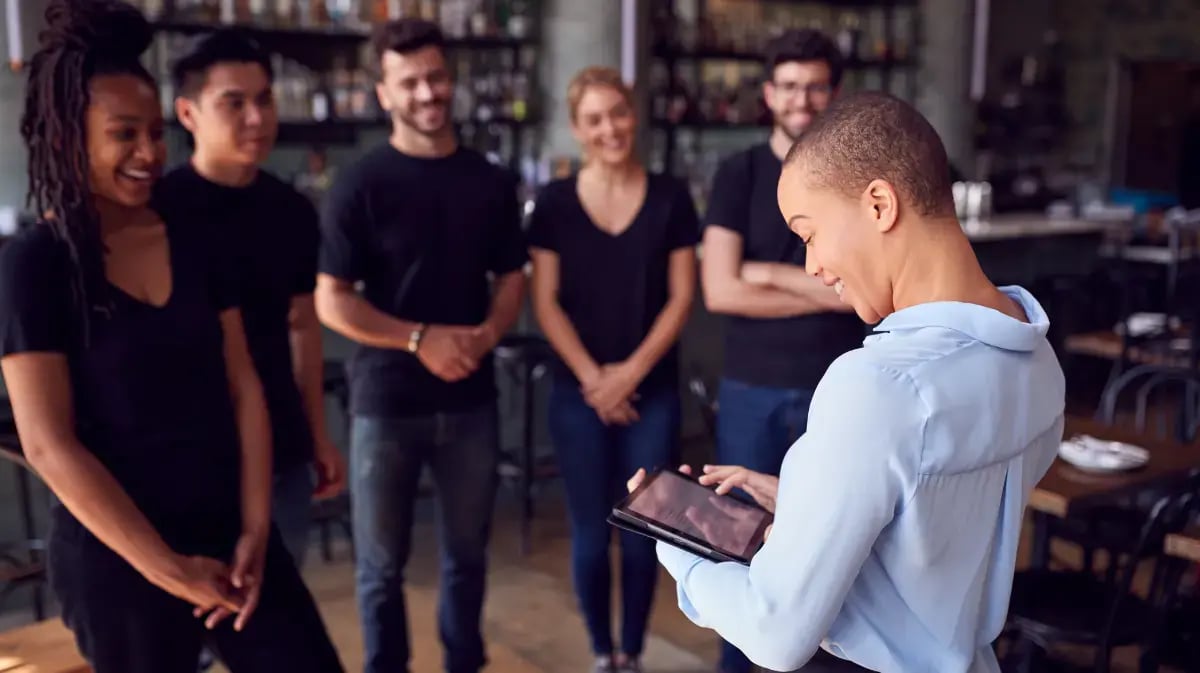 restaurant manager gathered around other employees