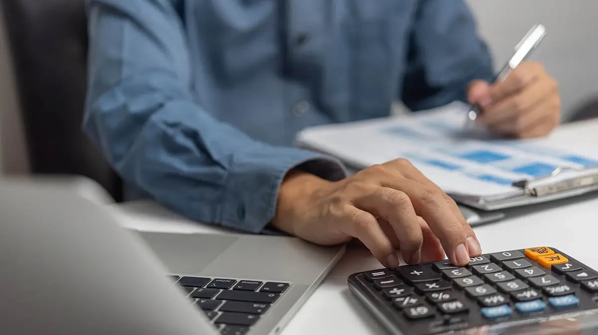 accountant's hand typing on a calculator