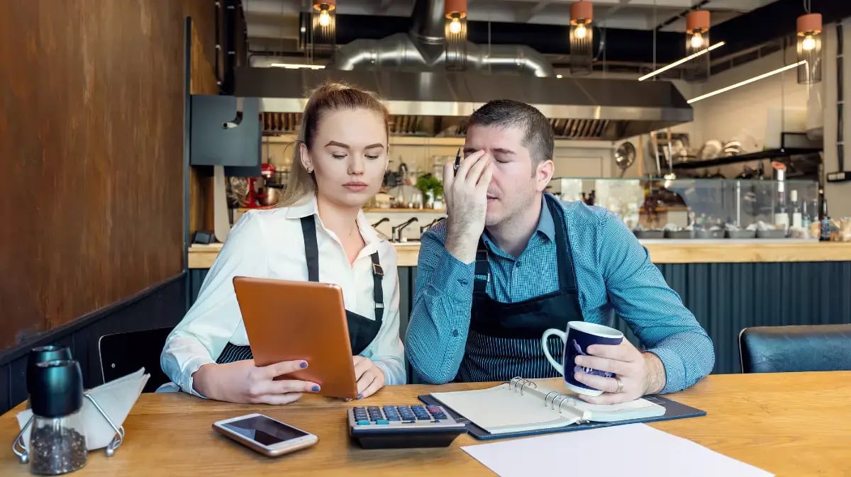 Two business owners reviewing together looking stressed