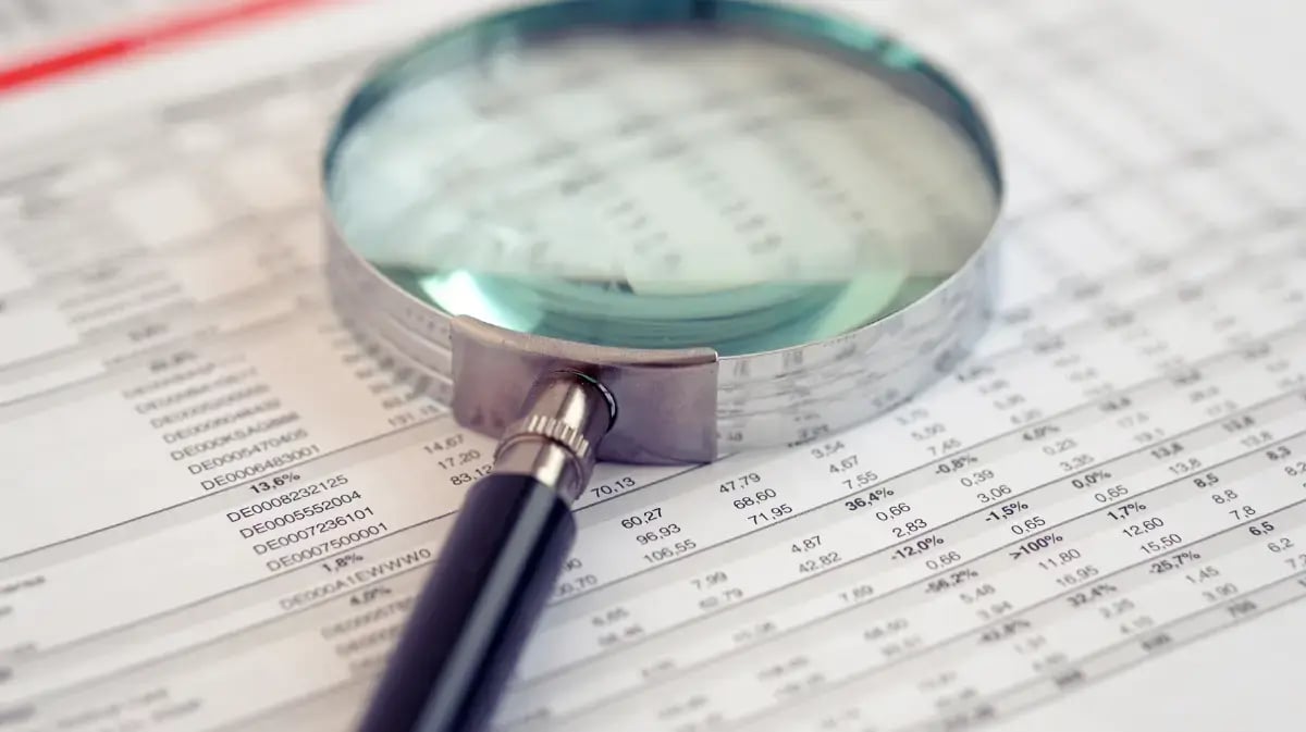 Magnifying glass on top of financial reports