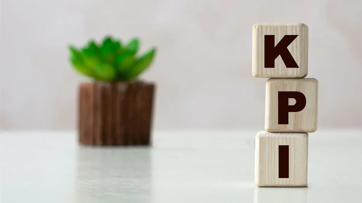 KPI blocks on a tabletop with a plant in the background